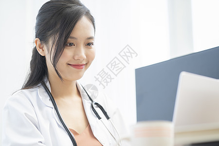 电脑体检正在微笑工作的漂亮女医生背景