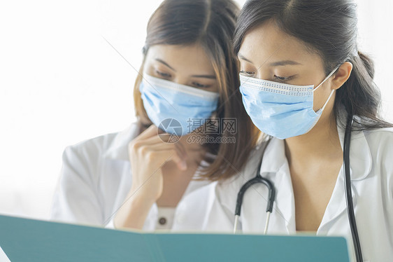 戴着口罩讨论患者病情的女医生图片