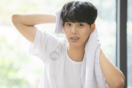 青年男子拿着毛巾擦头发图片素材