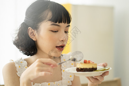 下午茶吃甜品的年轻女子图片