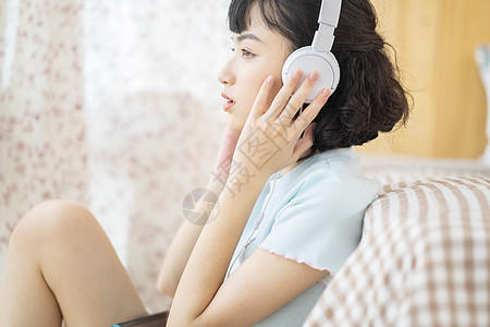 戴着耳机听音乐放松的可爱少女图片