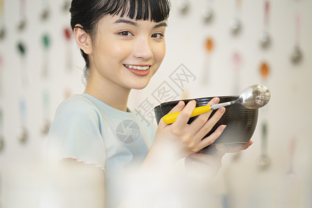 居家烹饪品尝美食的齐刘海女孩图片