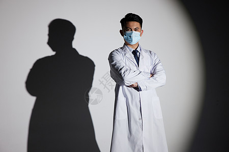 恐龙影子聚光灯下戴口罩的医生形象背景