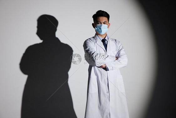聚光灯下戴口罩的医生形象图片