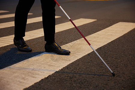 盲人拿着导盲杖过人行横道特写图片