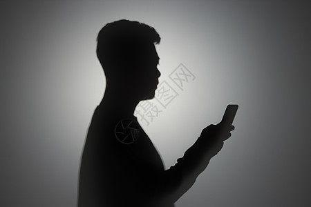 男性使用手机剪影背景图片
