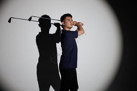聚光灯下的男性打高尔夫球背景图片
