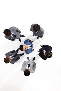 俯拍商务男性被同事伙伴围在中间图片