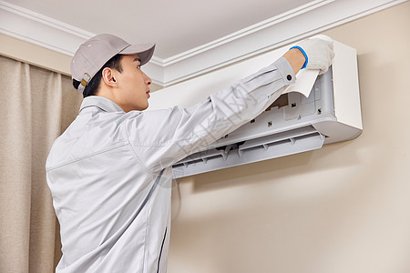电器  维修男性工人清洁空调机背景