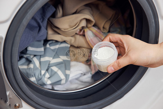 洗衣粉放进滚筒洗衣机特写图片