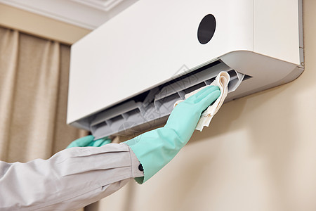技术服务维修工人使用抹布清洁空调机特写背景