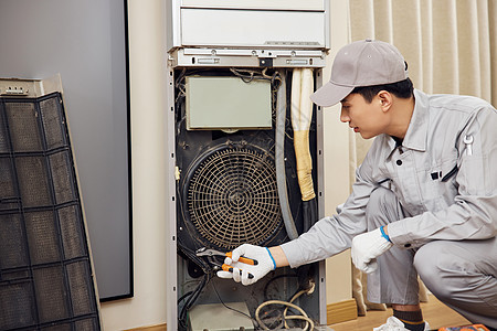 男性维修工人拆卸立式空调机图片