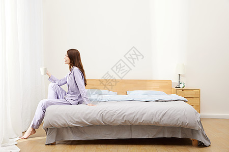 早上起床坐在床边的精致女生高清图片