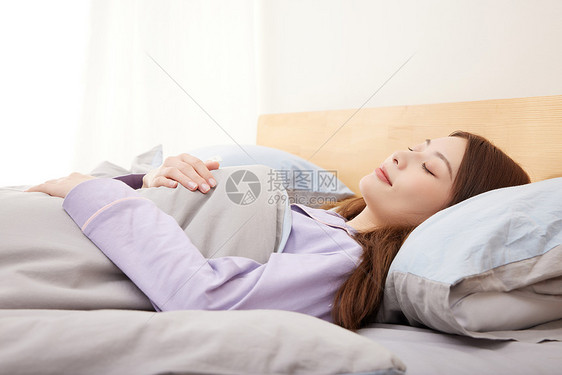 年轻女性躺在床上睡觉图片