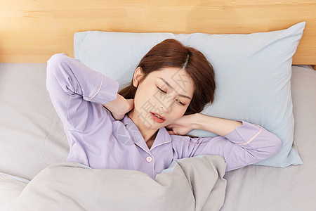 睡觉的女人躺在床上颈椎感到不适的年轻女性背景