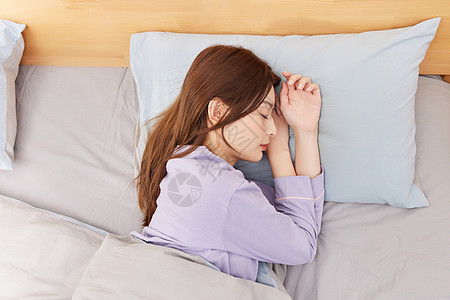 躺在床上睡觉的年轻女性图片