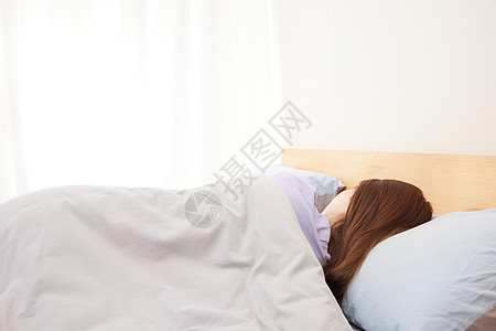 躺在床上睡觉的女性背影图片