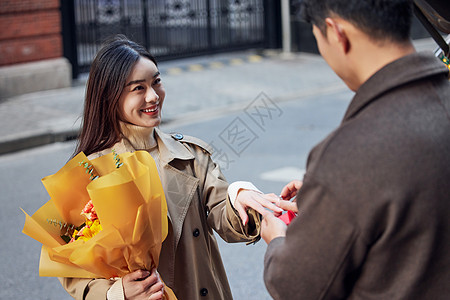 户外男性向女友求婚戴戒指高清图片