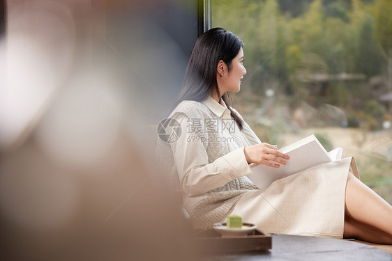 女性度假在房间里看书图片