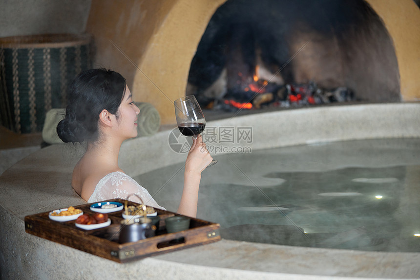 夜晚女性泡温泉喝红酒
