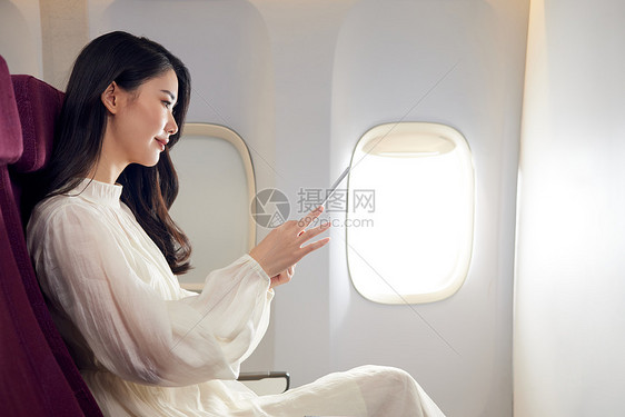 年轻美女飞机上办公图片