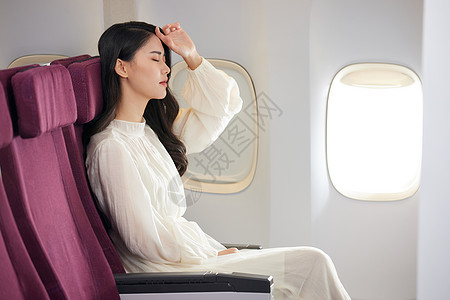 年轻女性飞机上休息图片