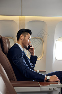 商务男士侧面商务男士机舱内使用手机背景