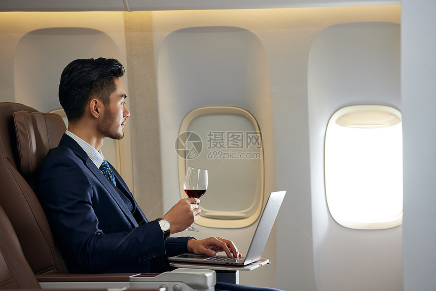 飞机商务舱上喝红酒的精英白领图片