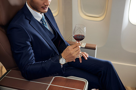 商务男士在机舱里喝红酒图片