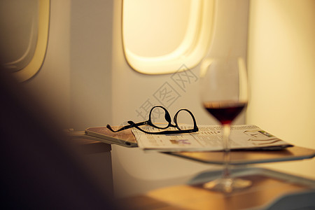 飞机商务车座椅上的报纸和眼镜图片