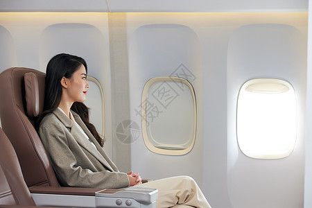 年轻商务女性乘坐飞机出差图片
