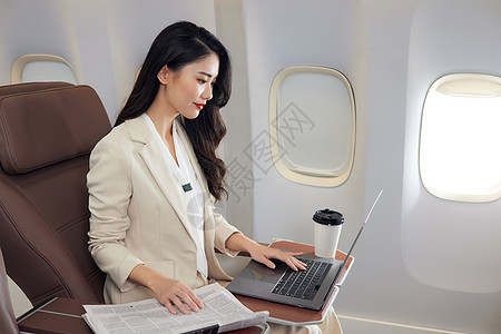 年轻商务女性飞机上办公图片
