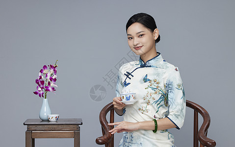 年轻旗袍女性品茶背景图片