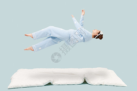 穿着睡衣的年轻少女悬浮在空中图片
