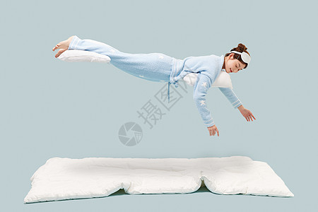 穿着睡衣的年轻少女悬浮在空中背景图片