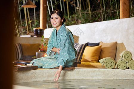 穿着日式浴衣的女性坐在温泉旁边玩水高清图片