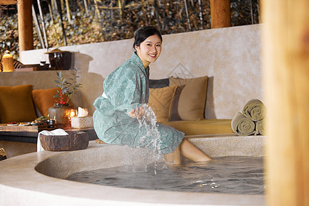 穿着日式浴衣的女性坐在温泉旁边玩水图片
