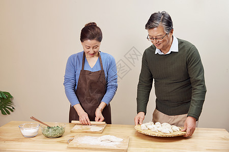 夫妻二人在家包饺子背景图片