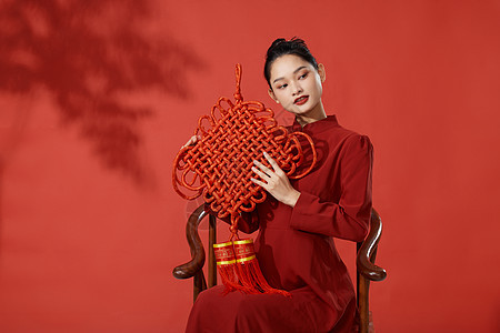 穿旗袍的年轻女子手拿中国结图片