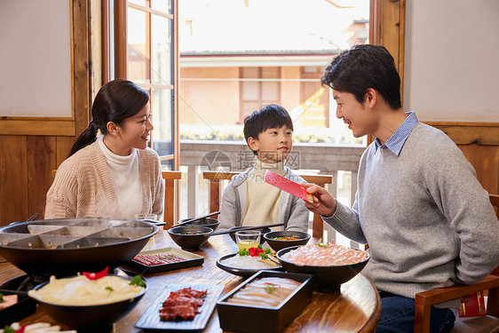 在火锅店吃火锅发红包过新年的家庭图片