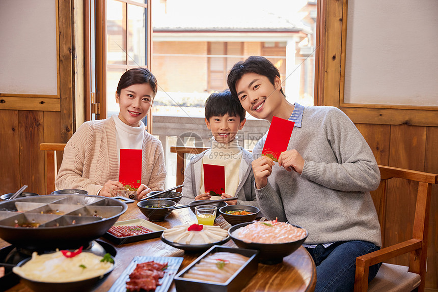 火锅店吃火锅发红包的新年家庭图片