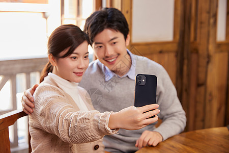 在火锅店拿手机自拍的夫妻图片