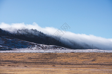 川西塔公草原的雪山云雾背景图片