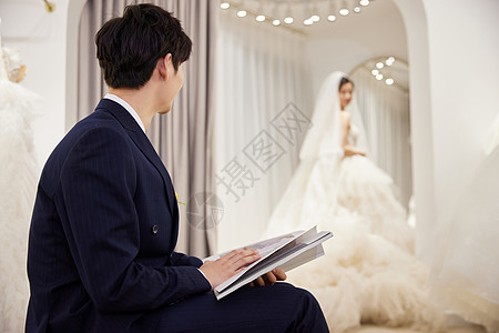 男性在婚纱店等待女友换装图片