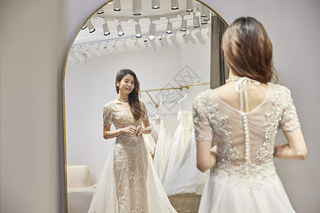 结婚礼服穿着婚纱站在镜子前的新娘背景