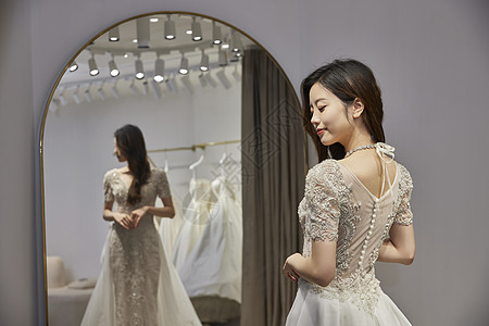 新娘穿着婚纱站在镜子前图片
