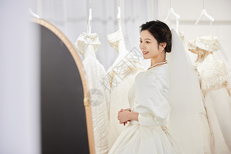 结婚礼服挑选婚纱的新娘照镜子背景