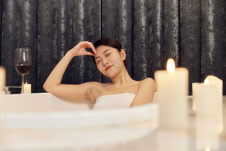 夜晚躺在浴缸里泡澡的女性背景图片