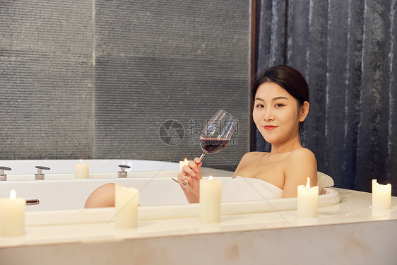 年轻美女浴缸泡澡喝红酒图片