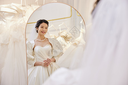 镜子前穿着婚纱的美丽新娘图片